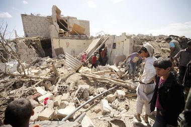 People inspect damage at a house after it was destroyed by a Saudi-led air strike in Yemen's capital Sanaa