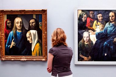 A visitor looks at paintings by Han van