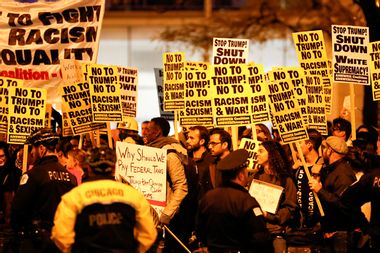 Protesters hold signs during a protest against Republican president-elect Donald Trump outside Trump International Hotel and Tower in Chicago