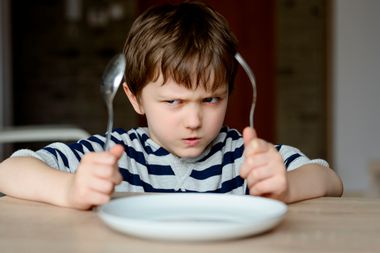 Upset little boy waiting for dinner