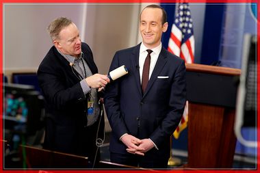 White House Press Secretary Spicer removes lint from Senior White House Advisor Miller's jacket as he waits to go on the air in the White House Briefing Room in Washington.