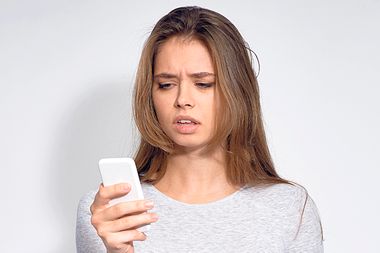 Confused Woman Looking at Phone