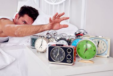 Man shutting off alarm clocks