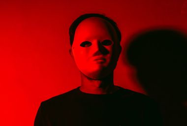 Man in white Halloween mask with red light