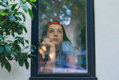 Teenage girl looking through window