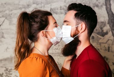 Young Couple Wearing Masks Kissing