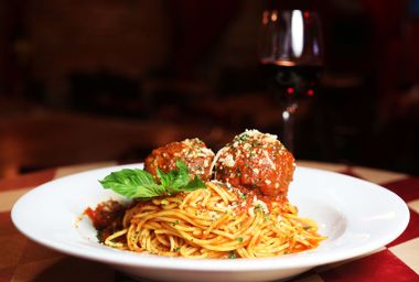 Spaghetti and meatballs served with red wine at a restaurant