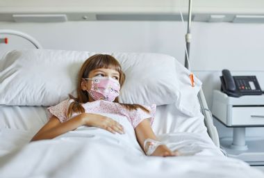 Sick girl lying on bed in ICU during COVID-19