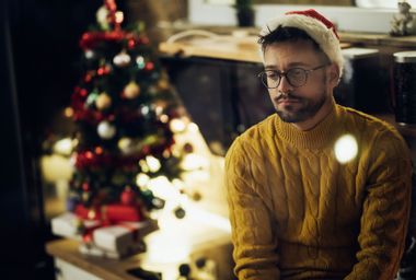 Young sad man spending Christmas Eve alone at home
