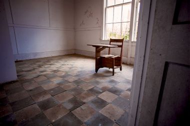 Abandoned Old Wooden School Desk in Empty Classroom