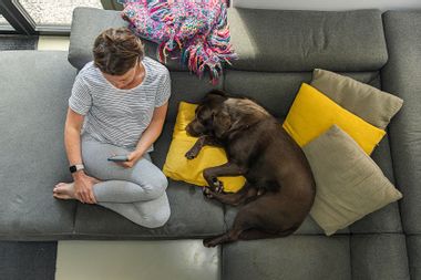 Woman sitting on the couch with her dog