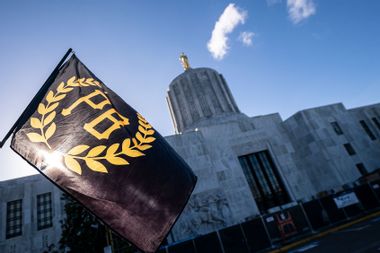 A Proud Boy flag flies in front of the Oregon state capitol
