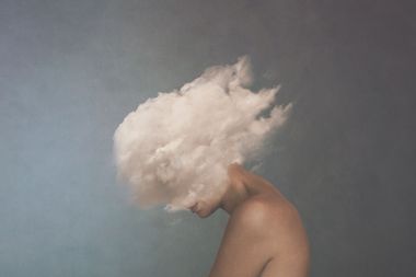 Surreal image of a white cloud covering a woman's face