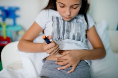 Diabetic girl injecting insulin in her stomach
