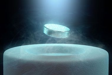 Image concept of magnetic levitating above a high-temperature superconductor, cooled with liquid nitrogen