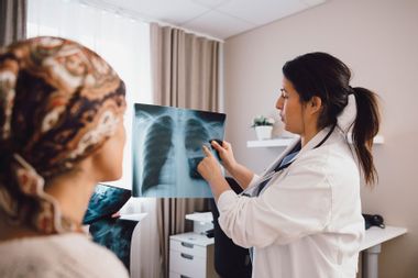 Doctor advising cancer patient while examining x-ray