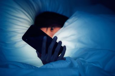 Woman using smart phone late at night