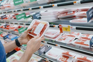 Man checking the price of ground beef at supermarket