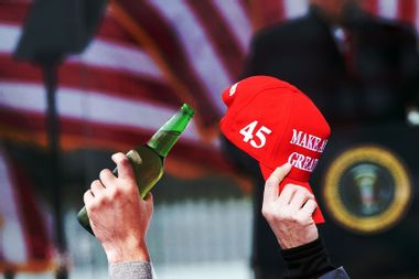Trump supporters holding up a MAGA hat and a beer
