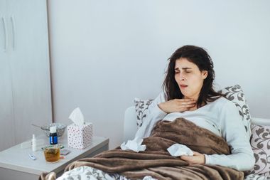 Woman Suffering From A Cold Lying In Bed