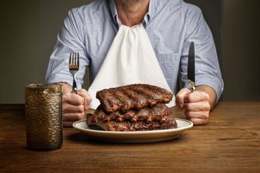 Man about to eat large stack of ribs