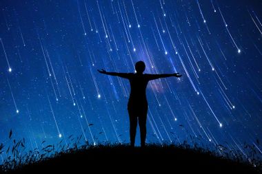 A girl standing in the midst of the stars at night
