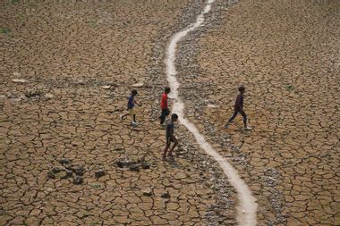 Children crossing a dried-up lake India
