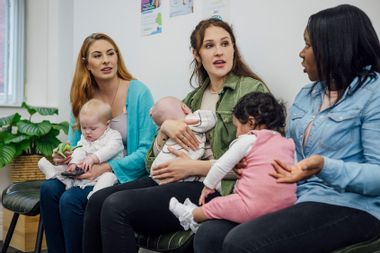 A shot of a group of women sitting together with their babies in the waiting room of a baby clinic