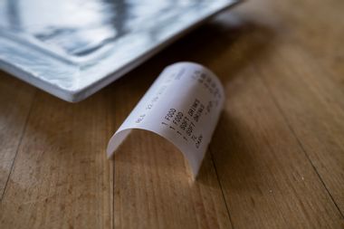 A receipt for food and drink on a table in a restaurant cafe.