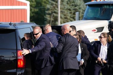Secret Service Members assist Donald Trump into car