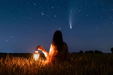 Woman with lantern watching comet passing