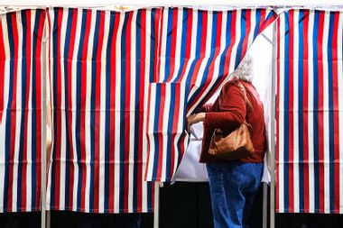 A person enters a voting booth