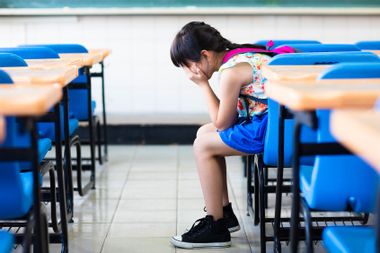 Sad girl sitting in a classroom