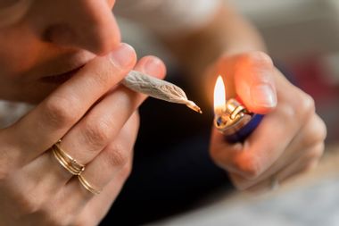 Woman lighting a marijuana joint