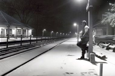 Man waiting for train in the snow Garden City LIRR station NYC
