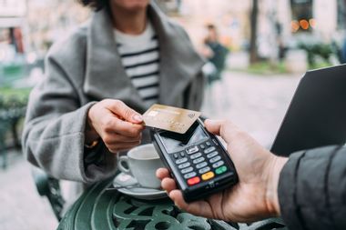 A customer making a contactless payment using a credit card.