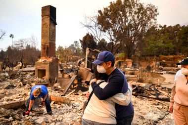 Family members embrace while viewing their burned home Los Angeles California 2192533134