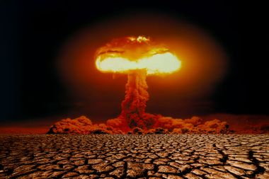 Nuclear explosion with mushroom cloud on scorched earth