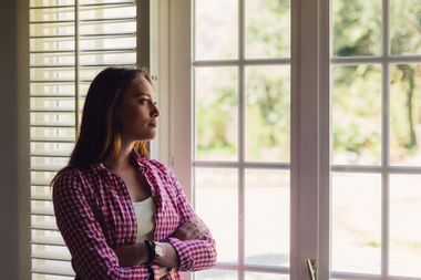 Depressed woman looking through window