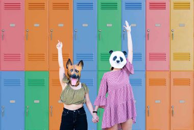 Teenage girls dressed in costumes with colorful school lockers in the background