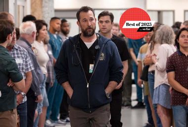 Actor Noah Wyle, dressed as a doctor with a stethoscope around his neck and an ID badge, walks through a hospital corridor lined with people in a scene from the TV show “The Pitt.” A red graphic in the corner reads “Best of 2025 … so far.”
