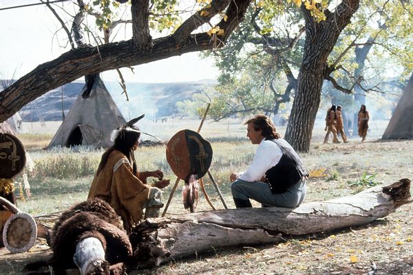 Kevin Costner talking with a Sioux Indian in a scene from the film Dances With Wolves