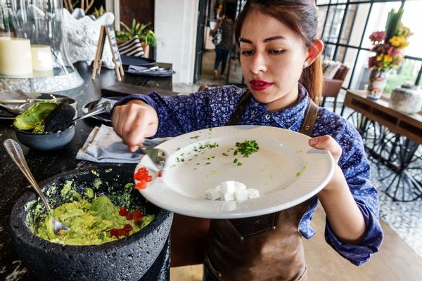 A waitress preparing food on the table-side at El Balcon del Zocalo.