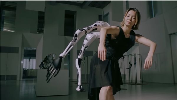 A dancer wears a robotic multi-arm backpack from Japanese company Jizai Arms, which she is able to control with AI assistance.