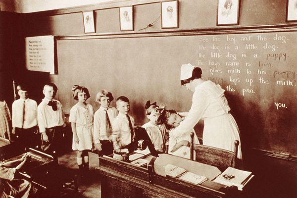 Nurse Examining School Children For Lice