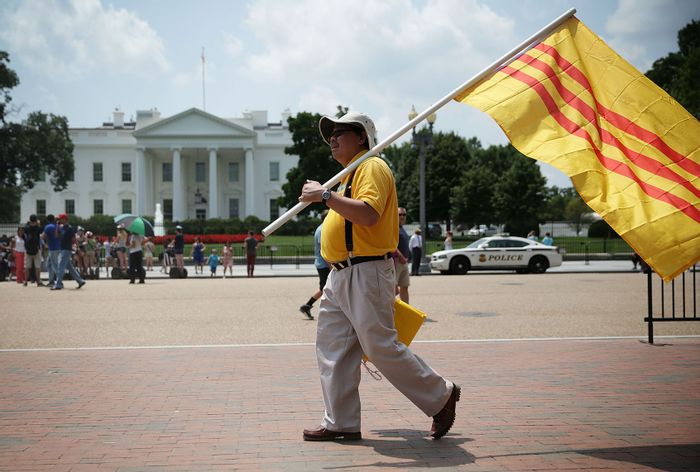 Vietnamese-American activist holds a South Vietnam flag as he participates in a protest outside the White House